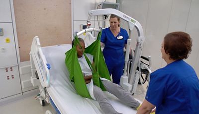 Close-up of doctor using tablet device in hospital hallway
