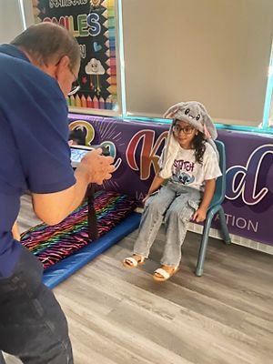 a man performs a vision screening on a young girl