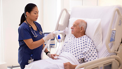 volara progressa mask on patient by nurse in hospital bed